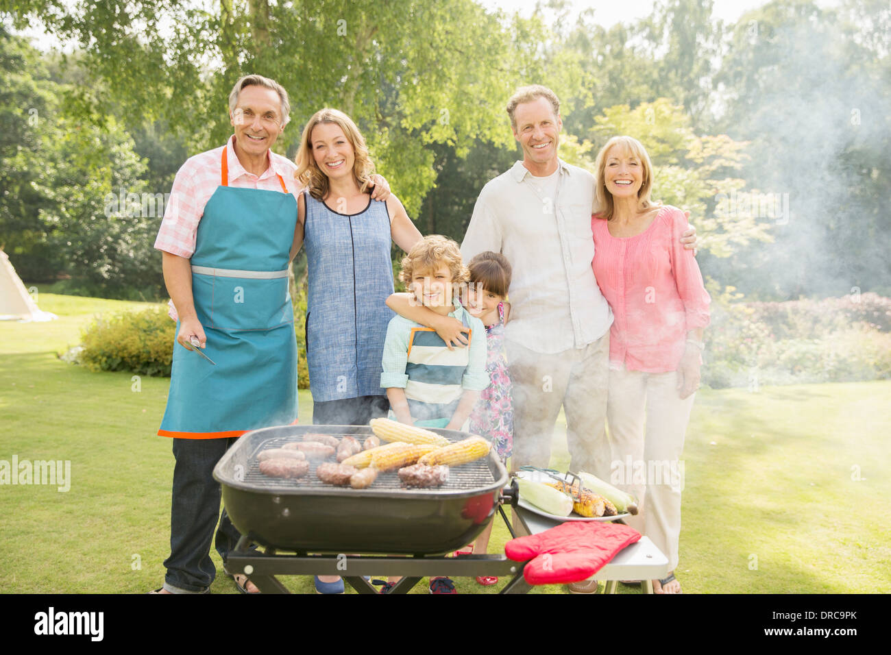 Generationsübergreifende Familie stehen am Grill im Garten Stockfoto