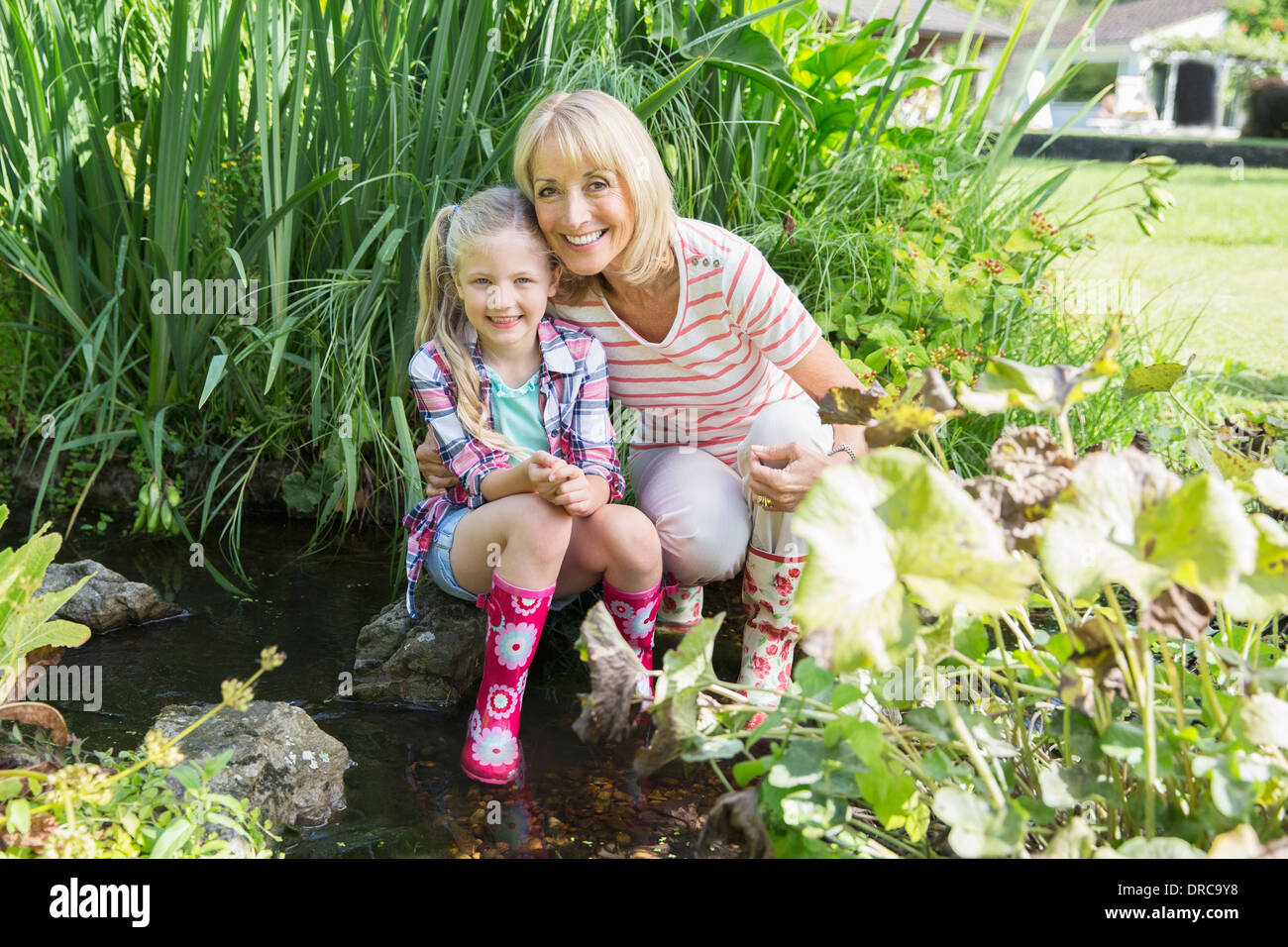 Großmutter und Enkelin lächelnd Teich Stockfoto