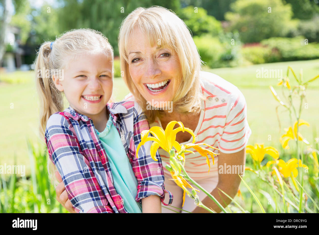 Großmutter und Enkelin lächelnd in Garten Stockfoto