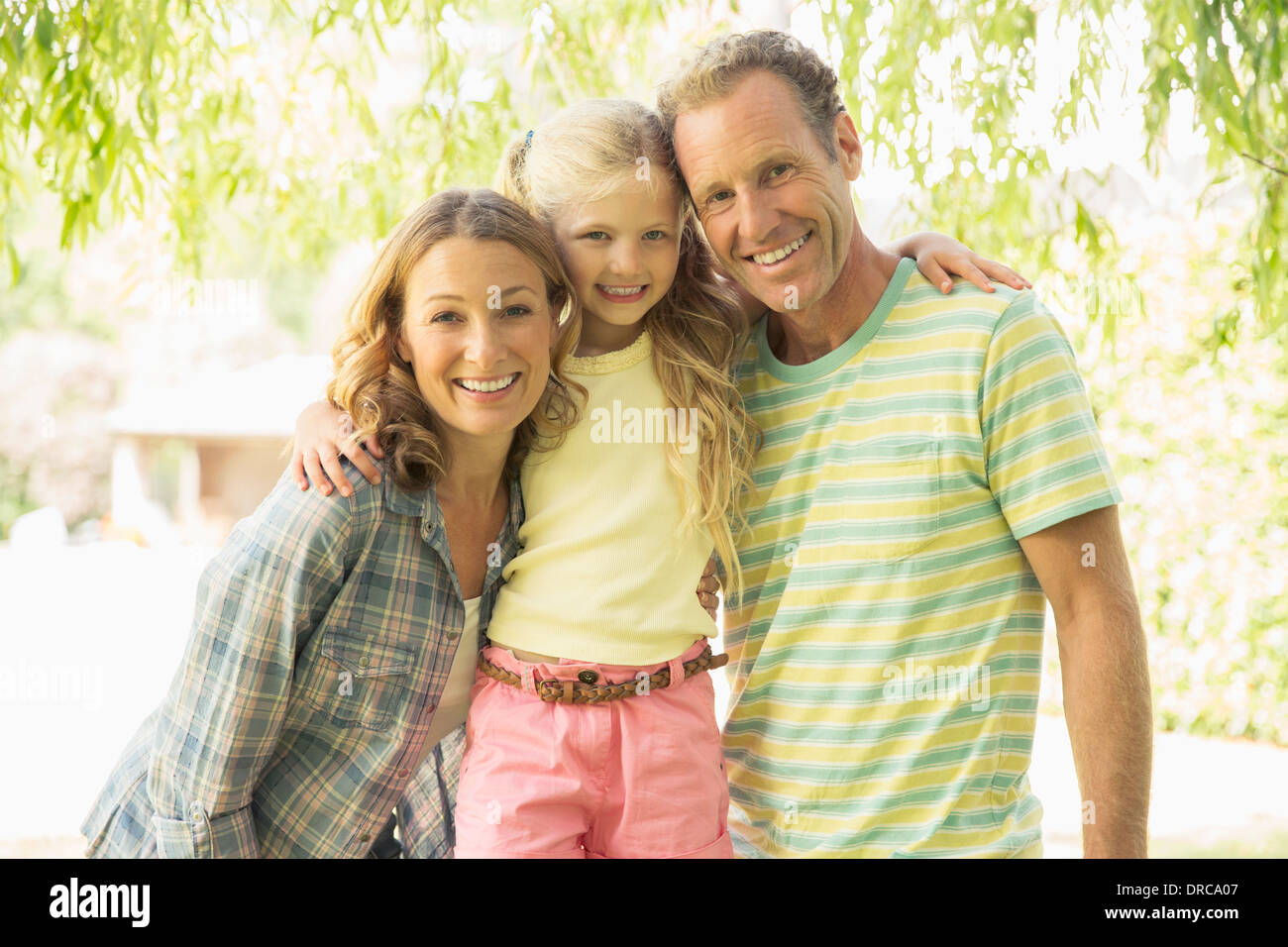 Familie lächelnd zusammen im freien Stockfoto