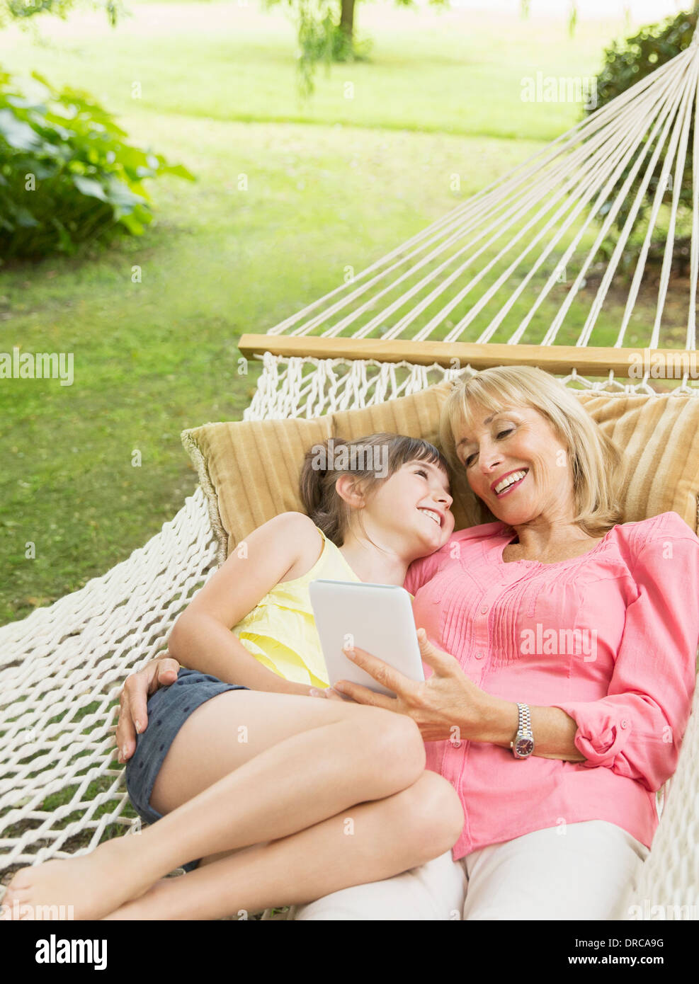 Großmutter und Enkelin mit digital-Tablette in Hängematte Stockfoto