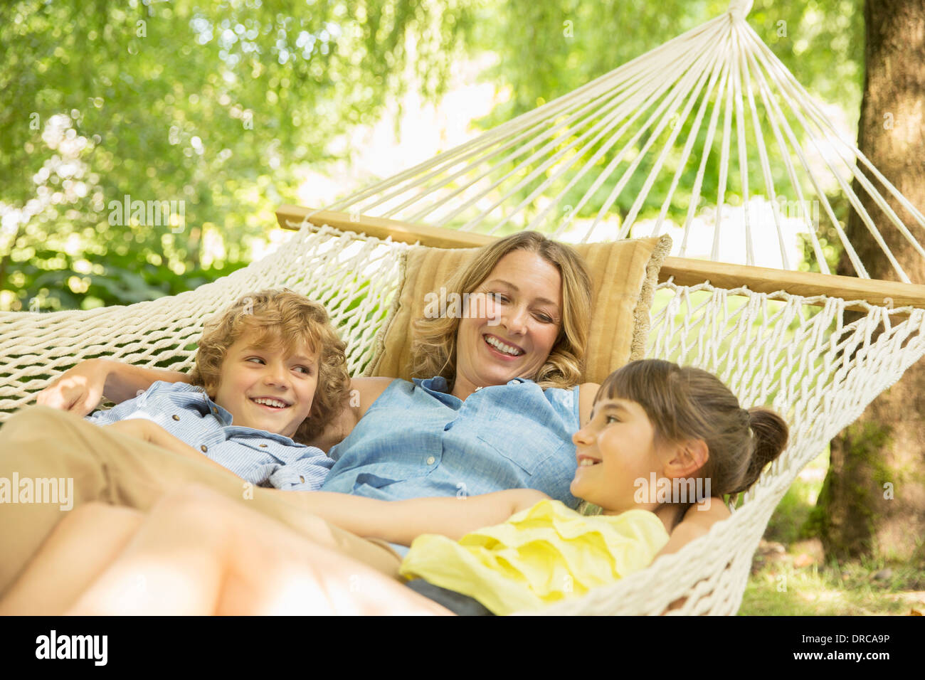 Mutter und Kinder gemeinsam in der Hängematte entspannen Stockfoto