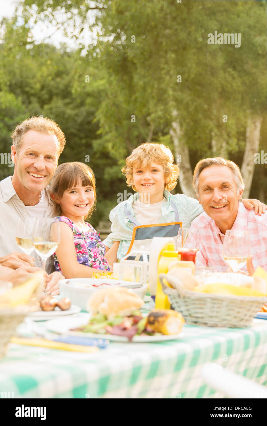 Mehr-Generationen-Familie beim Mittagessen am Tisch im Hinterhof Stockfoto