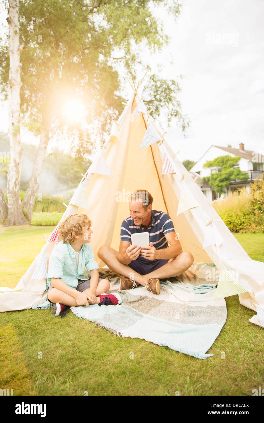Vater und Sohn mit digital-Tablette im Tipi im Hinterhof Stockfoto