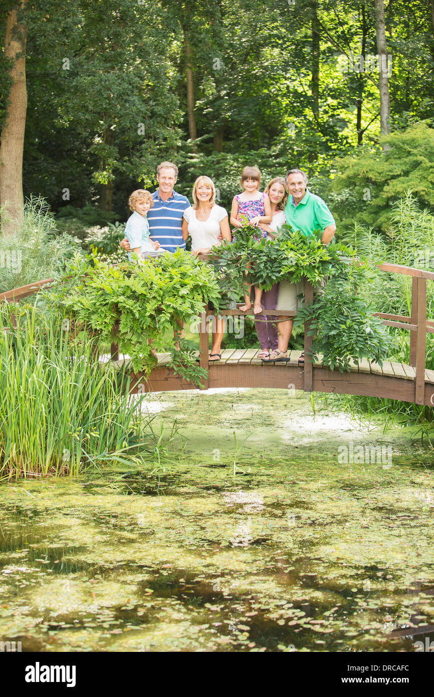Generationsübergreifende Familie stehen auf Holzsteg über Teich Stockfoto
