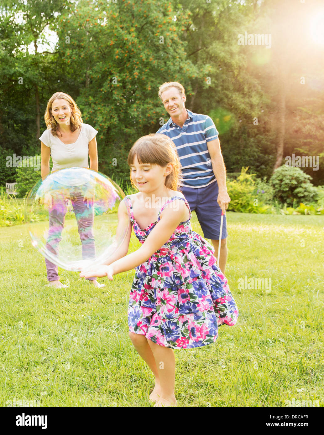 Familie spielen mit Luftblasen im Hinterhof Stockfoto