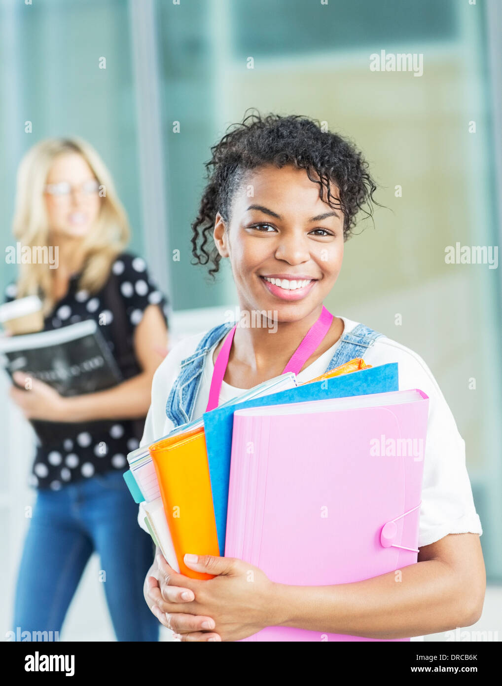 Lächelnde Studentin mit Ordnern Stockfoto