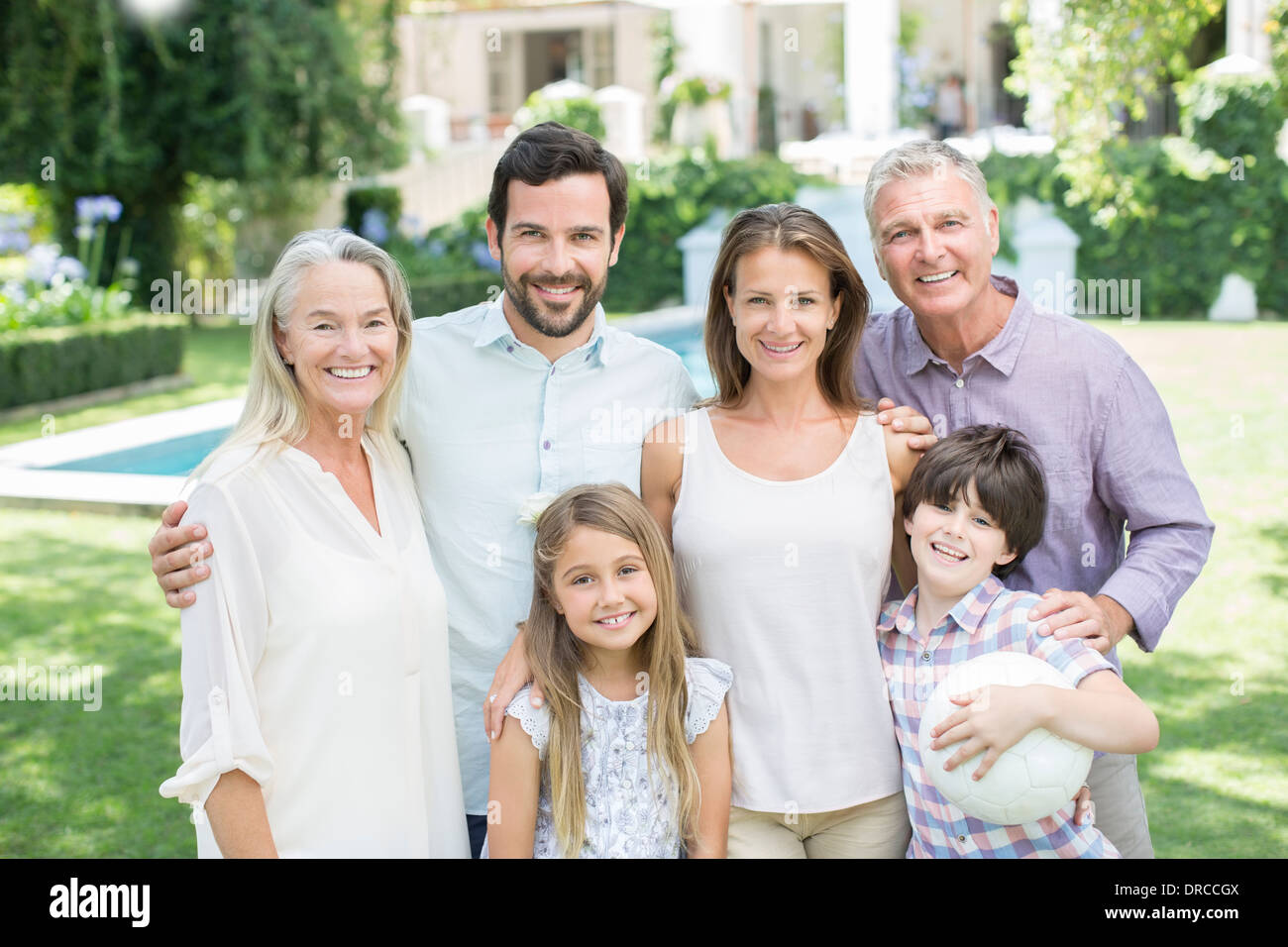 Mehr-Generationen-Familie lächelnd in Hinterhof Stockfoto