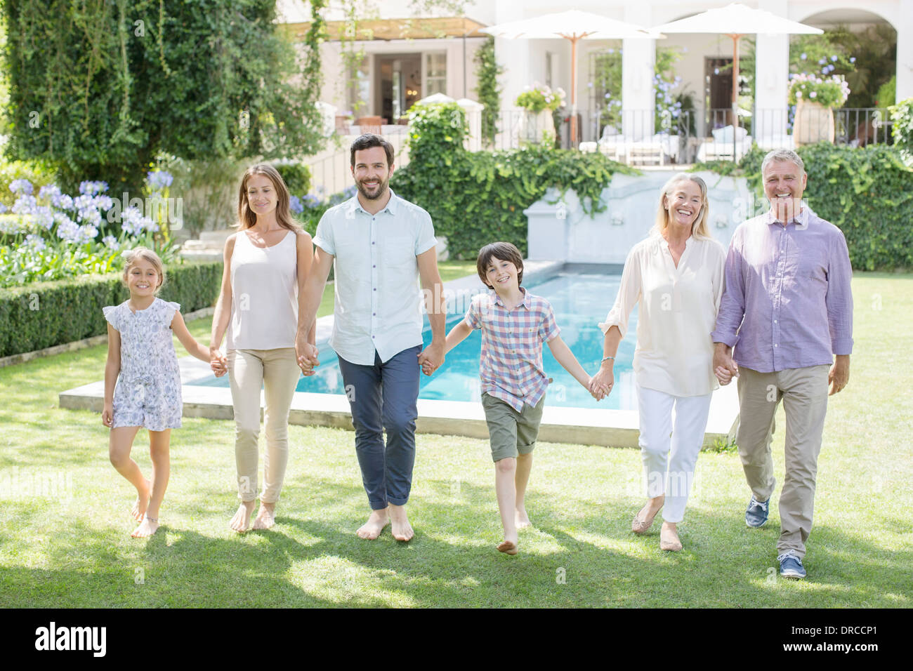 Mehr-Generationen-Familie Hand in Hand und Wandern im Hinterhof Stockfoto