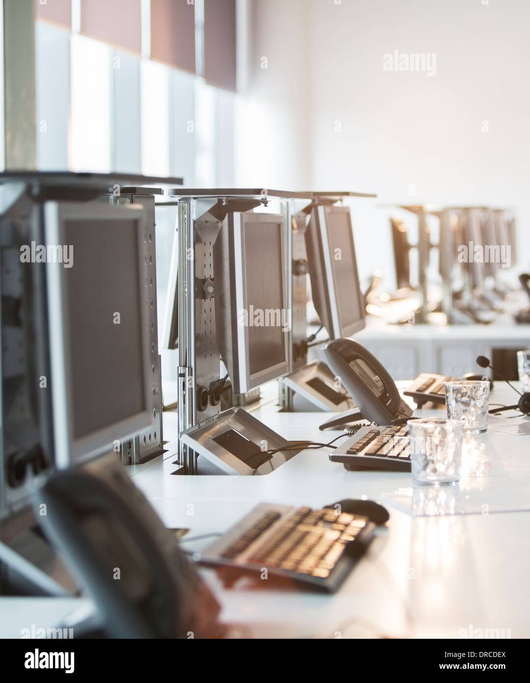 Computer und Telefon am Schreibtisch im Büro Stockfoto