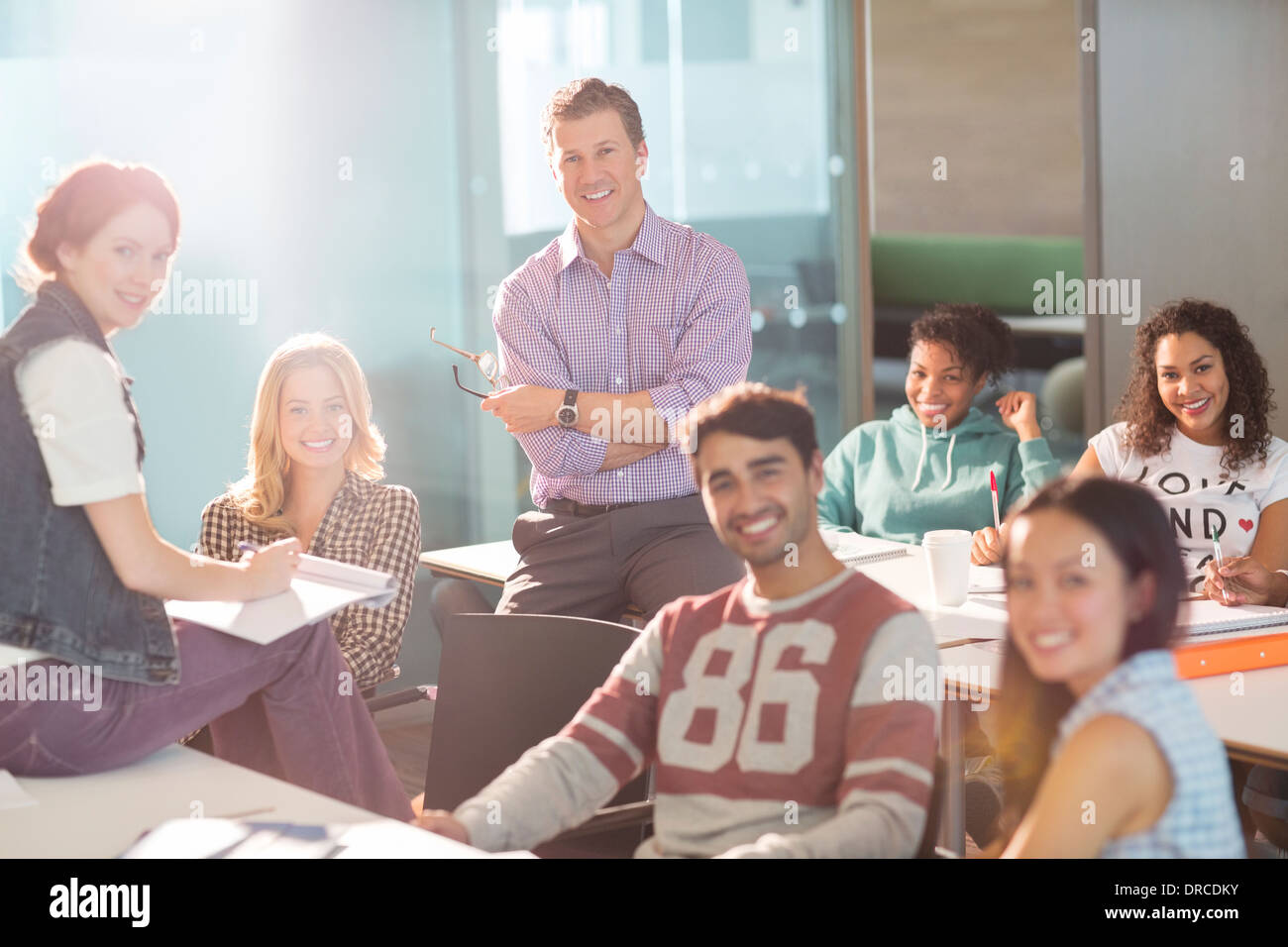 Professor und Studenten, die lächelnd im Klassenzimmer Stockfoto