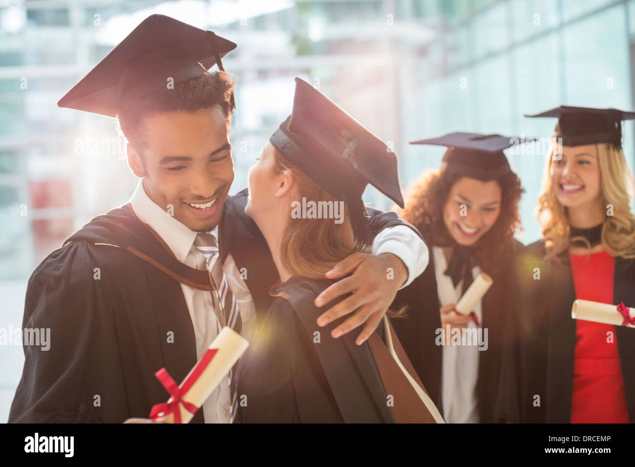Absolventinnen und Absolventen umarmt Stockfoto