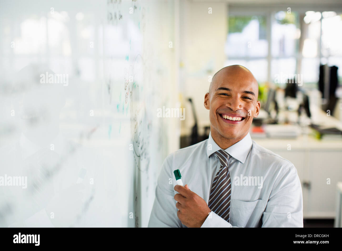 Geschäftsmann lächelnd am Whiteboard im Büro Stockfoto