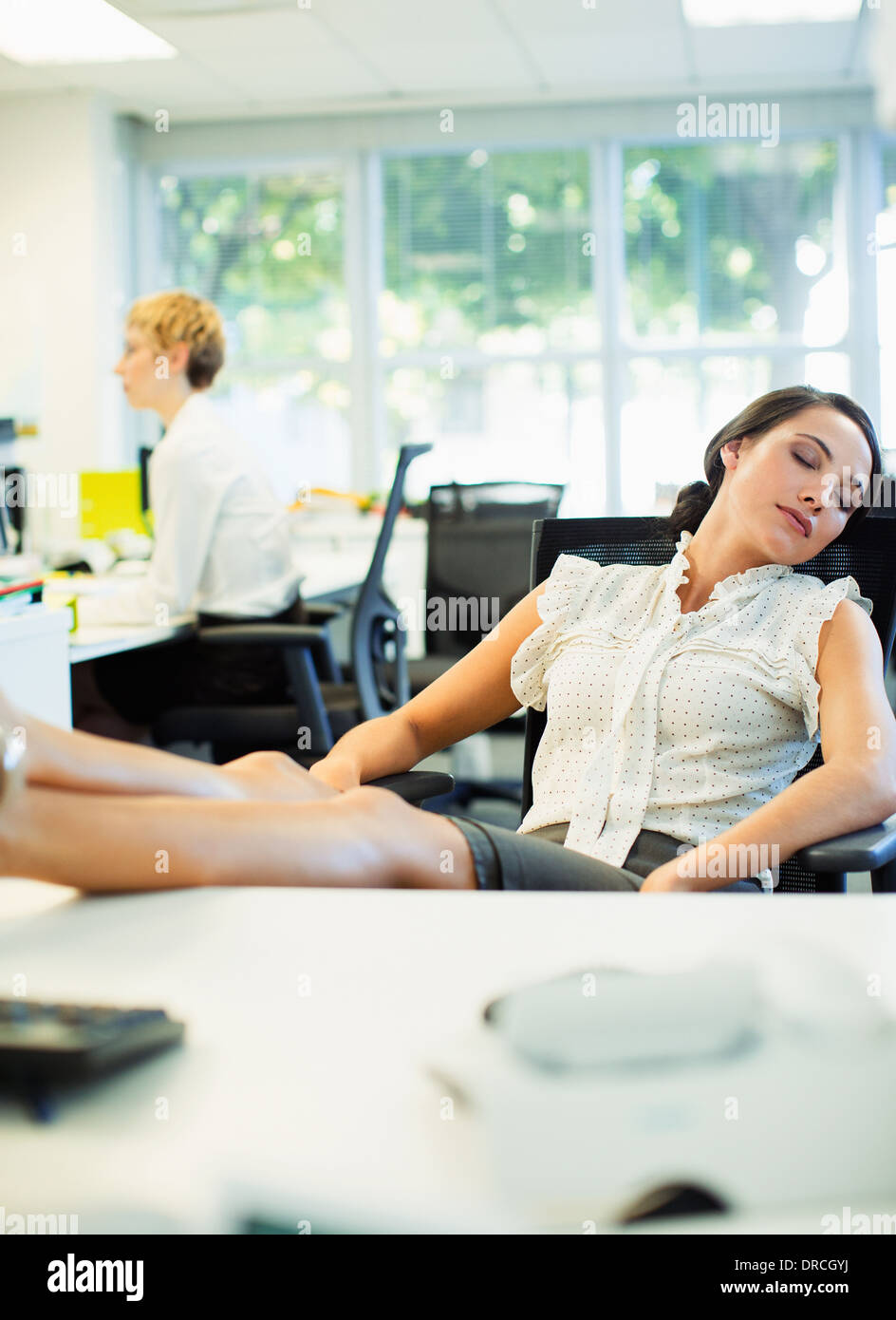 Geschäftsfrau Nickerchen am Schreibtisch im Büro Stockfoto
