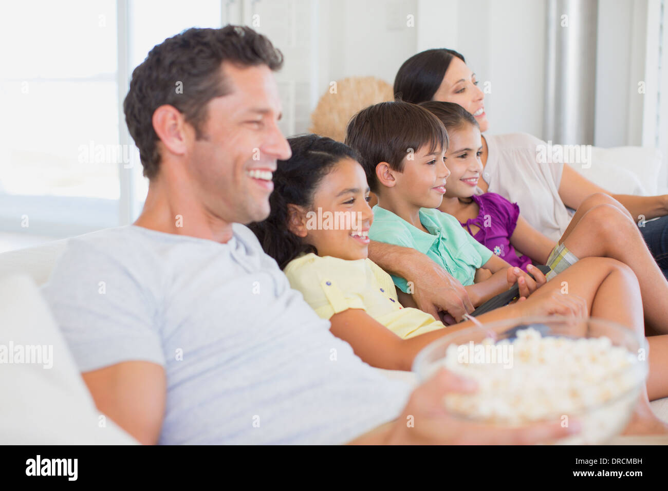 Familie vor dem Fernseher auf sofa Stockfoto