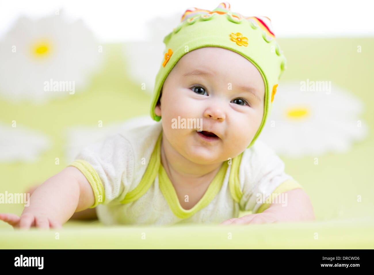 lächelnden Baby liegend auf grün Stockfoto