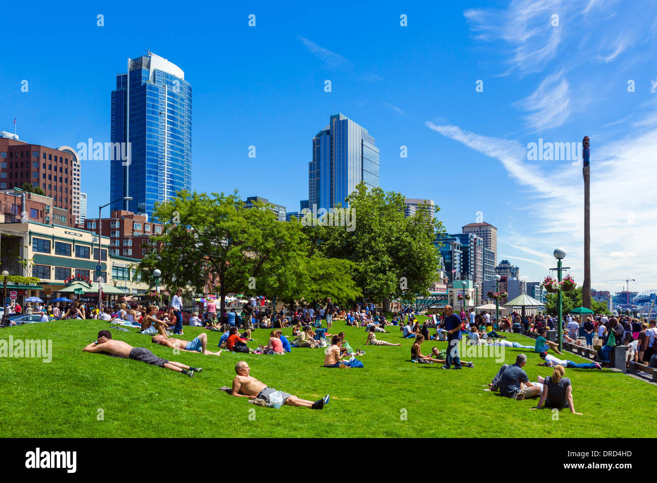 Menschen, die ein Sonnenbad im Victor Steinbrück Park vor der Skyline der Innenstadt, Seattle, Washington, USA Stockfoto