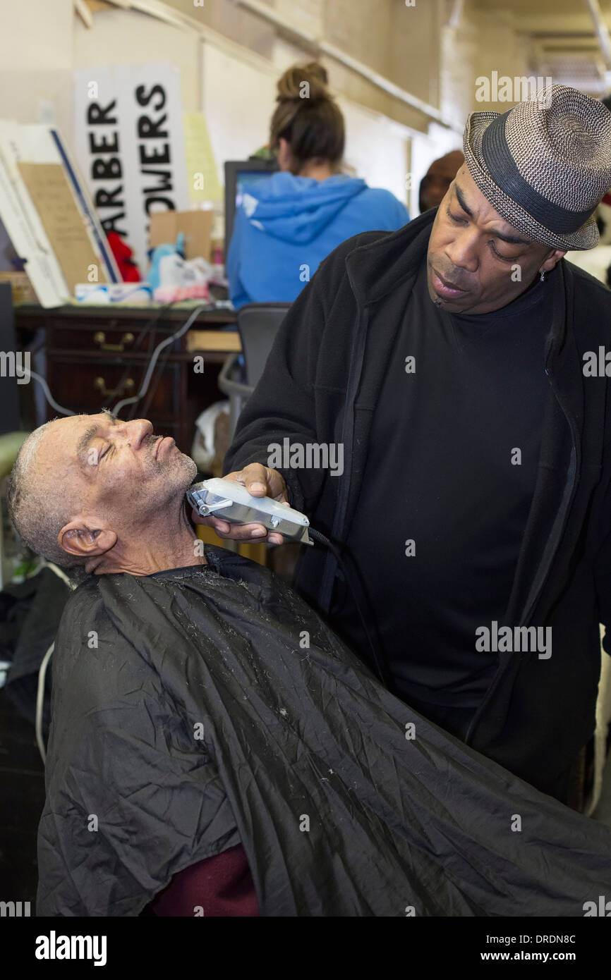 Detroit, Michigan - Barber Elvis Tucker gibt einen Haarschnitt und Rasur, ein Obdachloser Stockfoto