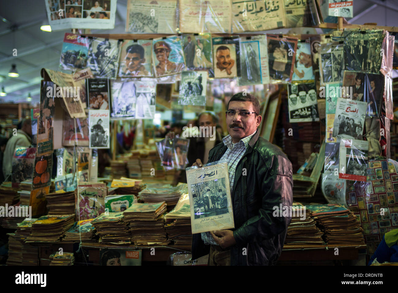 Kairo, Ägypten. 24. Januar 2014. Sayed Sadic, Inhaber eines second-hand Buchladen, führt eine alte Zeitschrift in seiner Buchhandlung während der internationalen Buchmesse in Kairo, Ägypten, 23. Januar 2014. Die Sadic ist seit über 100 Jahren in diesem Geschäft. Die 45. Kairo International Book Fair, eines der größten Buch der Welt, eröffnet für die Öffentlichkeit hier am Donnerstag. © Pan Chaoyue/Xinhua/Alamy Live-Nachrichten Stockfoto