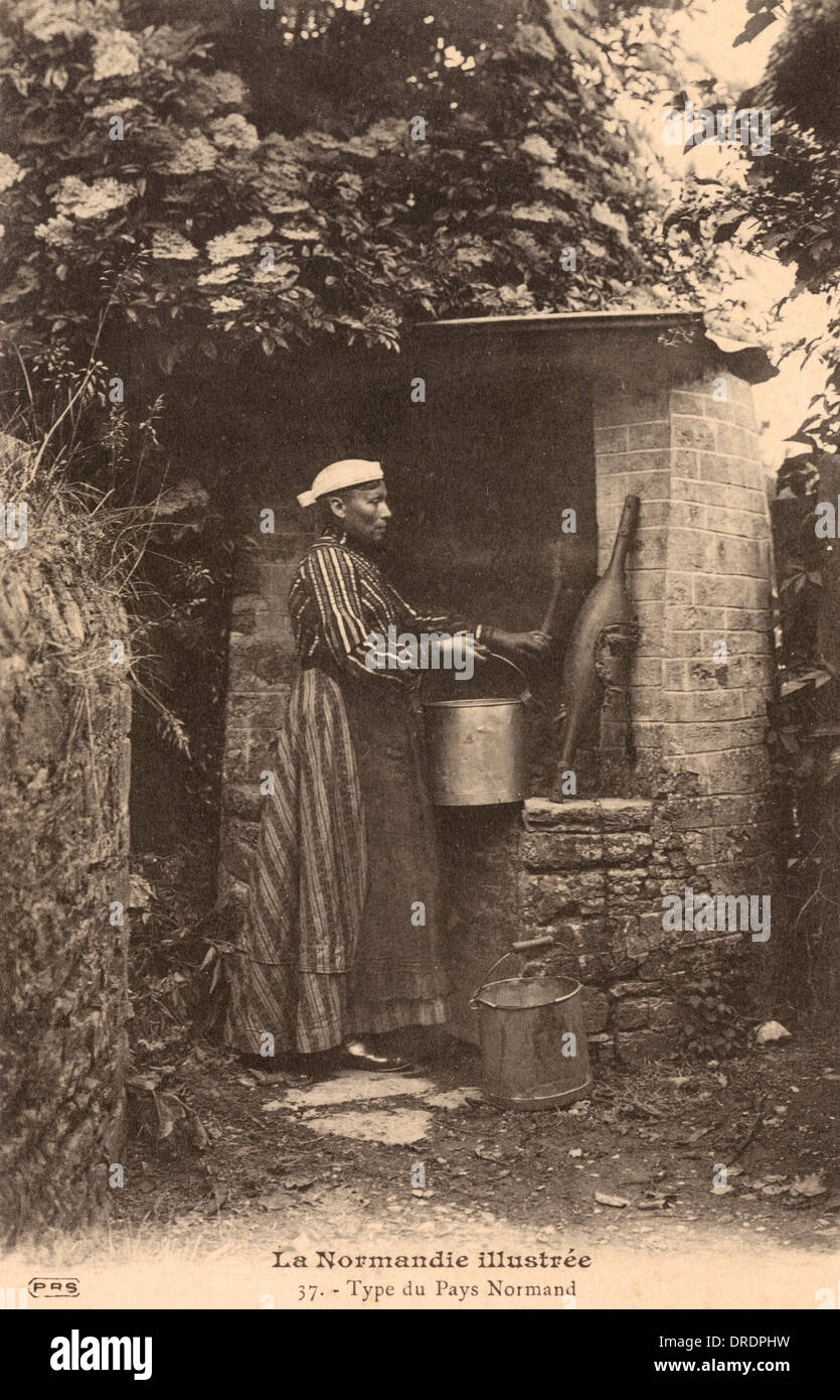 Eine Frau aus der Normandie am Brunnen Stockfoto