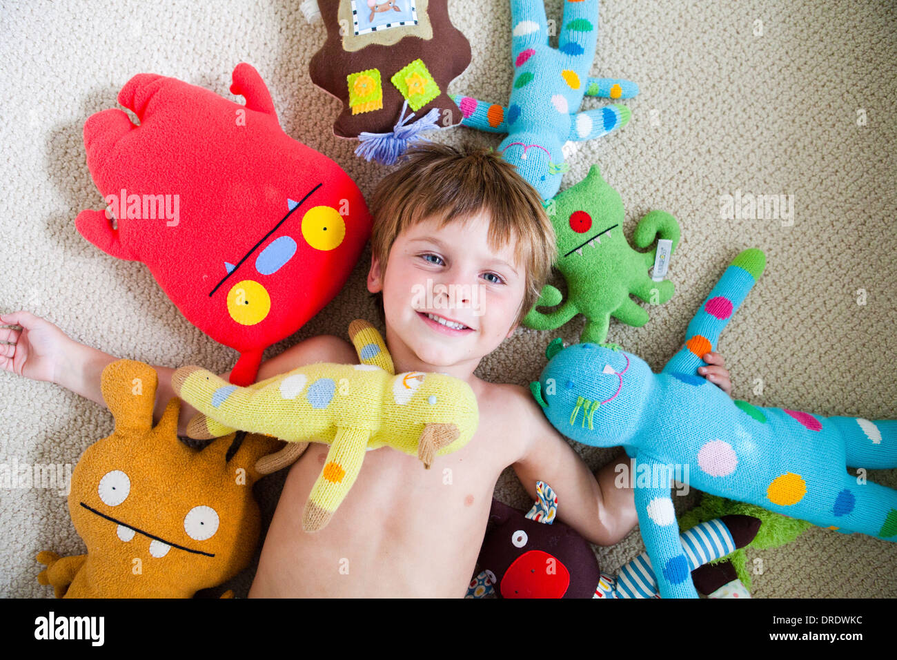 Kleiner Junge in Plüschtiere abgedeckt Stockfoto