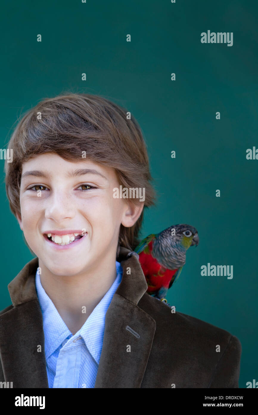 Junge mit Papagei auf der Schulter Stockfoto