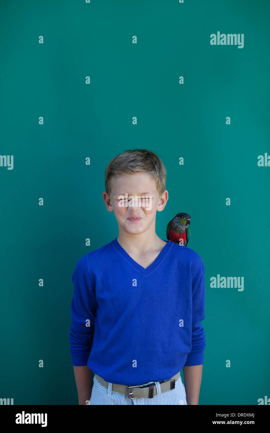 Junge mit Papagei auf der Schulter Stockfoto