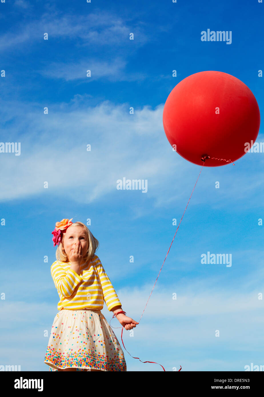 Mädchen außerhalb mit großen roten Ballon Stockfoto