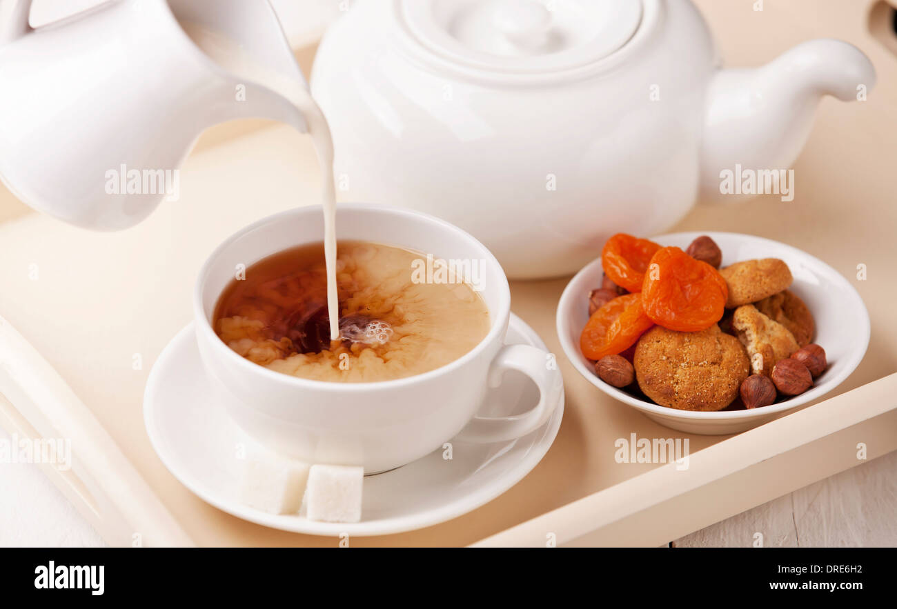 Frühstück mit einer Tasse Tee Milch und hausgemachte Kekse Stockfoto