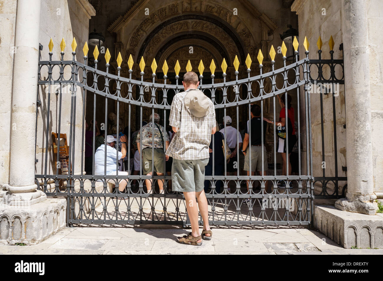 Menschen versammeln hinter einem Zaun in einer Kirche. darauf warten, in der Kathedrale, sondern ein Mann zu lassen ist ausgeschlossen Stockfoto