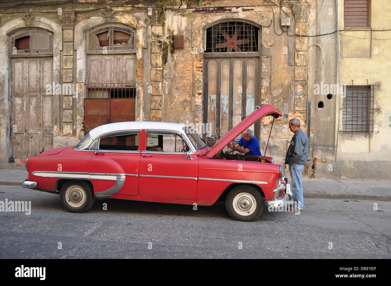 Havanna, Kuba: zwei Männer betrachten eine amerikanische Oldtimer auf einer Straße in der Innenstadt von Havanna Stockfoto