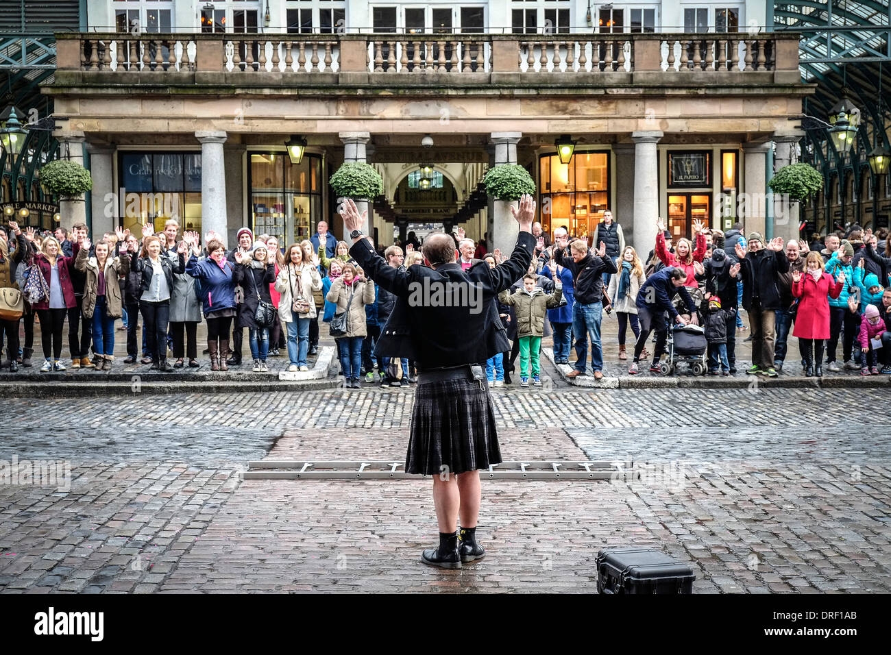 Pete Dobbing fördert eine Straße Entertainer am Covent Garden Piazza das Publikum zur Teilnahme an seine Leistung. Stockfoto