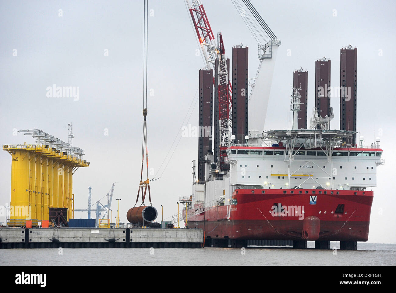 Cuxhaven, Deutschland. 21. Januar 2014. Das Installation-Schiff für den Bau des Offshore-Windparks "MPI Discovery" lades ein 60 Meter langes Stahlrohr, rief Monopile, um die Offshore-heavy-Duty-terminal in Cuxhaven, Deutschland, 21. Januar 2014. Riesige Eon Energie gechartert Spezialschiff für den Bau des Offshore-Windparks "Amrumbank West" in der Nordsee. EON hat nun mit dem Bau der Fundamente für den Windpark, etwa 37 Kilometer nordwestlich von Helgoland begonnen. Foto: INGO WAGNER/Dpa/Alamy Live News Stockfoto