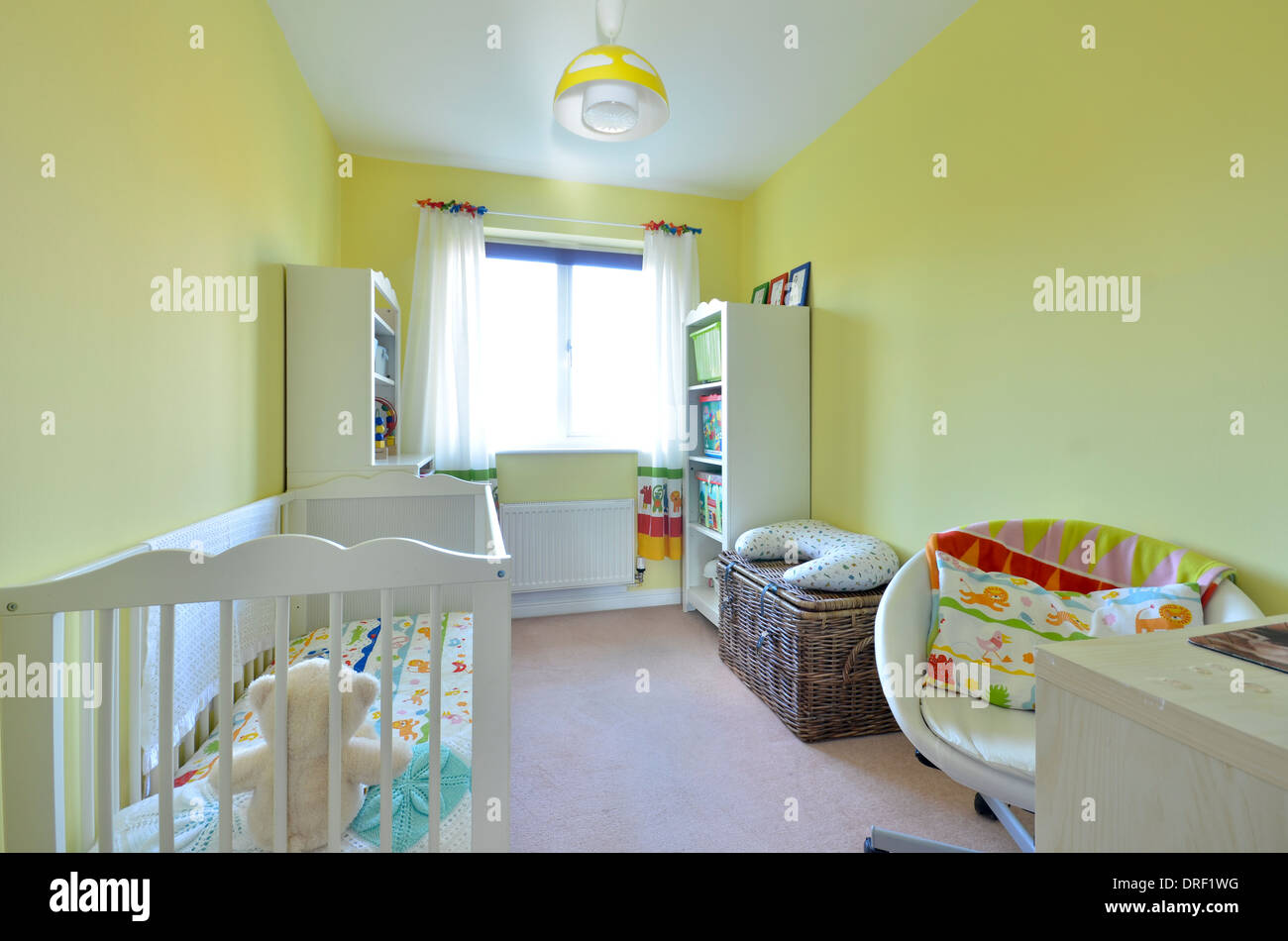 Childs Baumschule mit weißen Kinderbett und Zitrone Wände Stockfoto