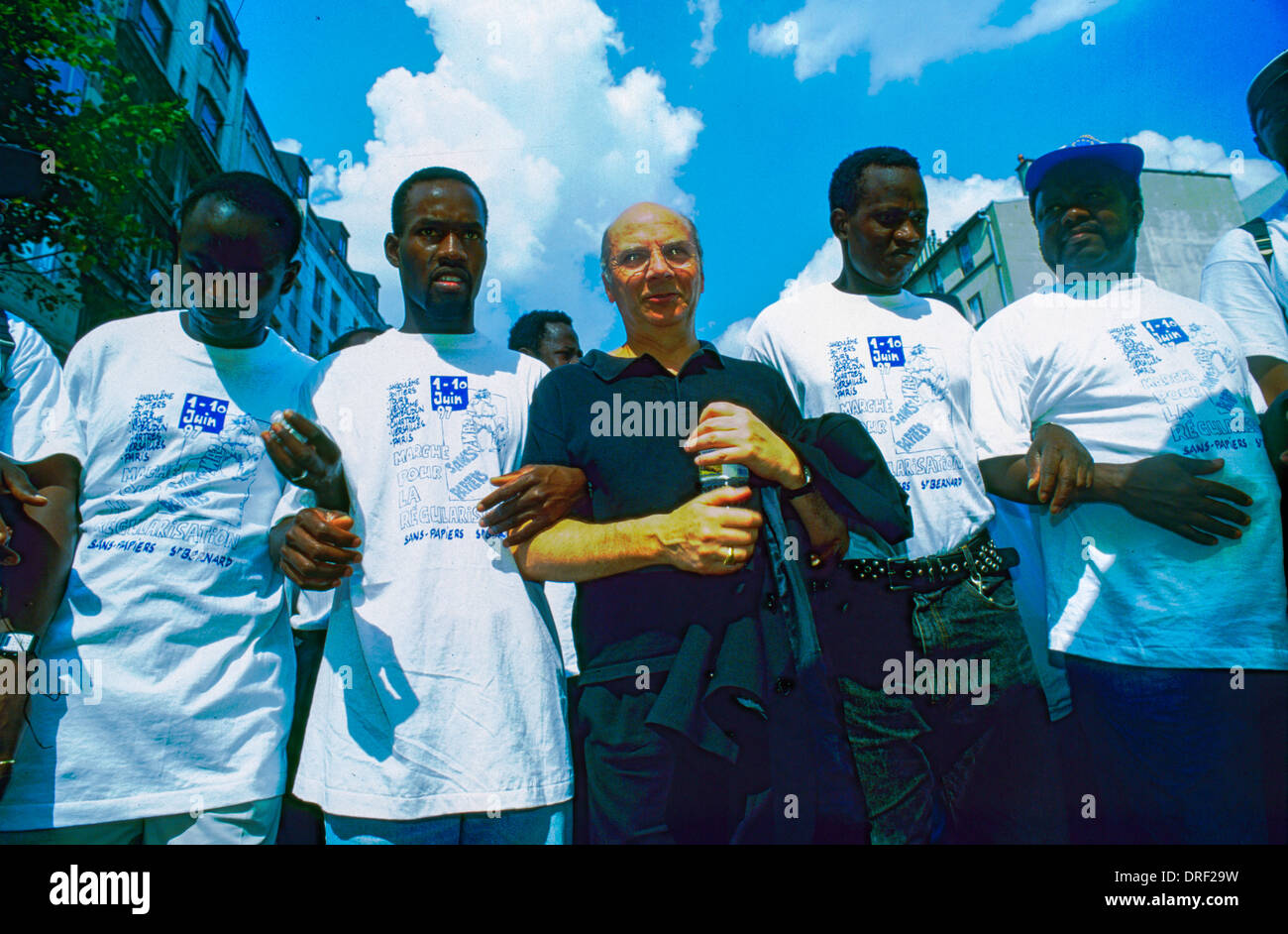 Paris, Frankreich, französischer Ex-katholischer Priester, Jacques Gaillot, Marsch Arm in Arm mit afrikanischen Migranten ohne Papiere, Protest "Sans Papiers", Diskriminierung, Jahrestag der "Eglise St." Bernands Besatzung, Demonstration auf der Straße, internationale Einwanderer, schwarze Gemeinde Paris, Demonstranten multirassischer Menschenrechte, multirassische Gruppe Stockfoto