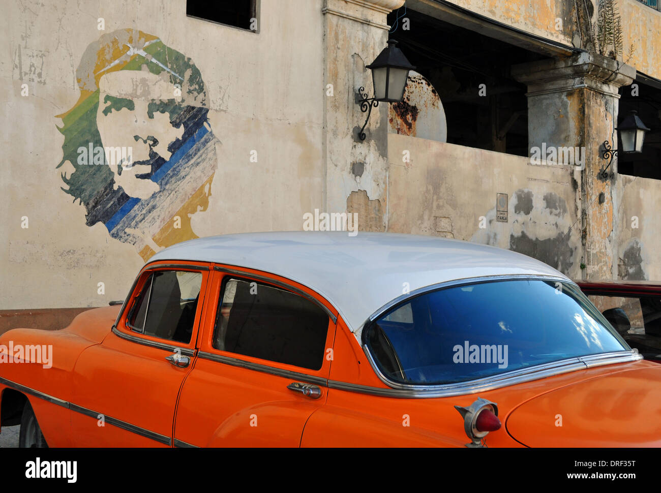 Havanna, Kuba: Oldtimer parkte neben Che Guevara Gemälde an der Wand in der Nähe von Havanna Docks. Stockfoto