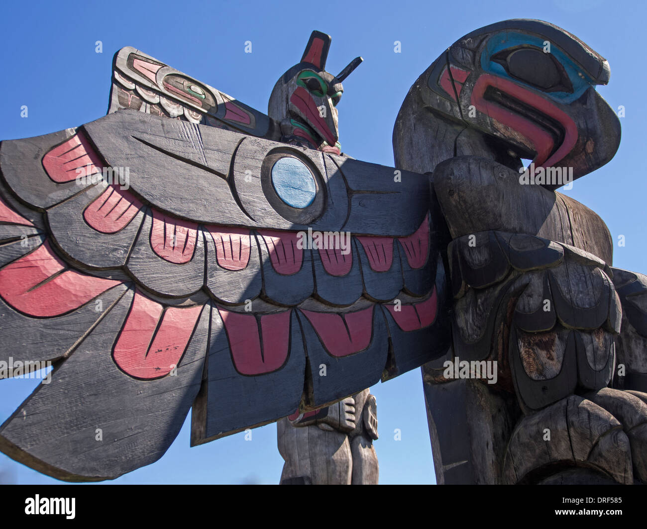 First Nations Geschichte Pol Schnitzereien auf der Messe in der Straße von Duncan, v. Chr. zeigen einen Adler mit einem Raben hinaus gegen ein helles Blau Stockfoto