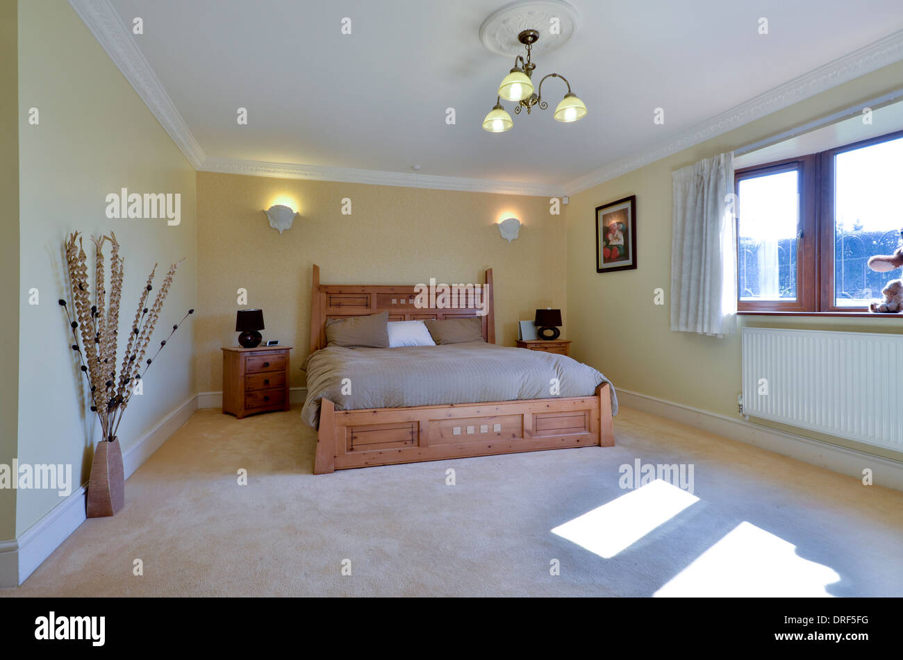 Beige Schlafzimmer mit Holz gerahmte Kingsize-Bett Stockfoto