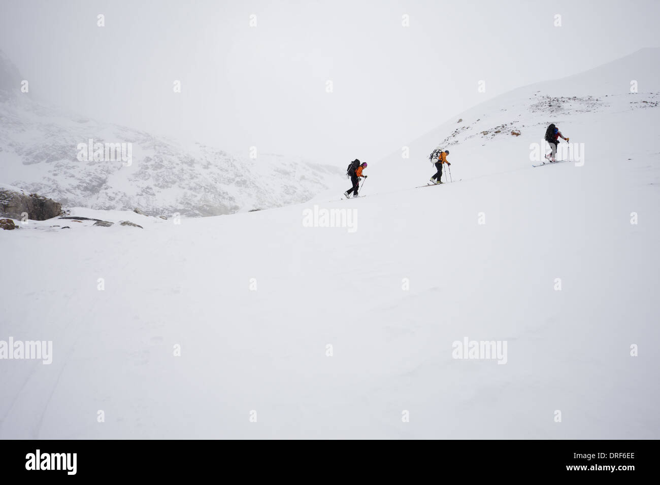 Alberta, Kanada. Drei Skifahrer aufsteigender Grat Nebel cloud-Kanada Stockfoto