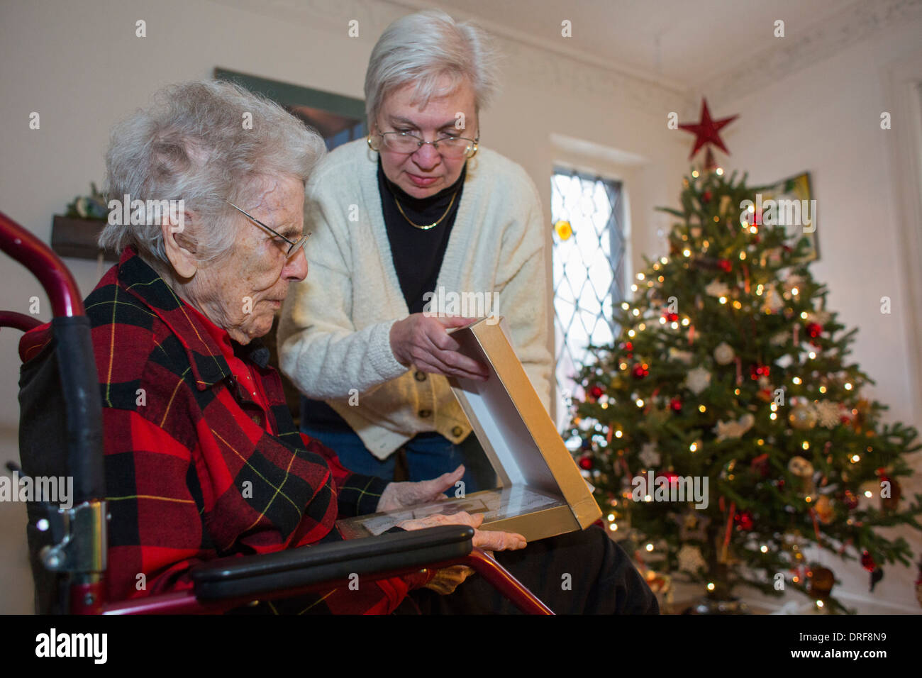 Detroit, Michigan - Dorothy Newell, 99, öffnet ein Weihnachtsgeschenk mit Hilfe ihrer Tochter, Susan Newell, 65. Stockfoto