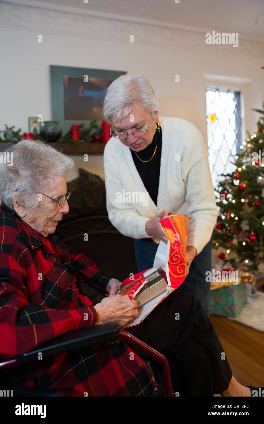 Detroit, Michigan - Dorothy Newell, 99, öffnet ein Weihnachtsgeschenk mit Hilfe ihrer Tochter, Susan Newell, 65. Stockfoto