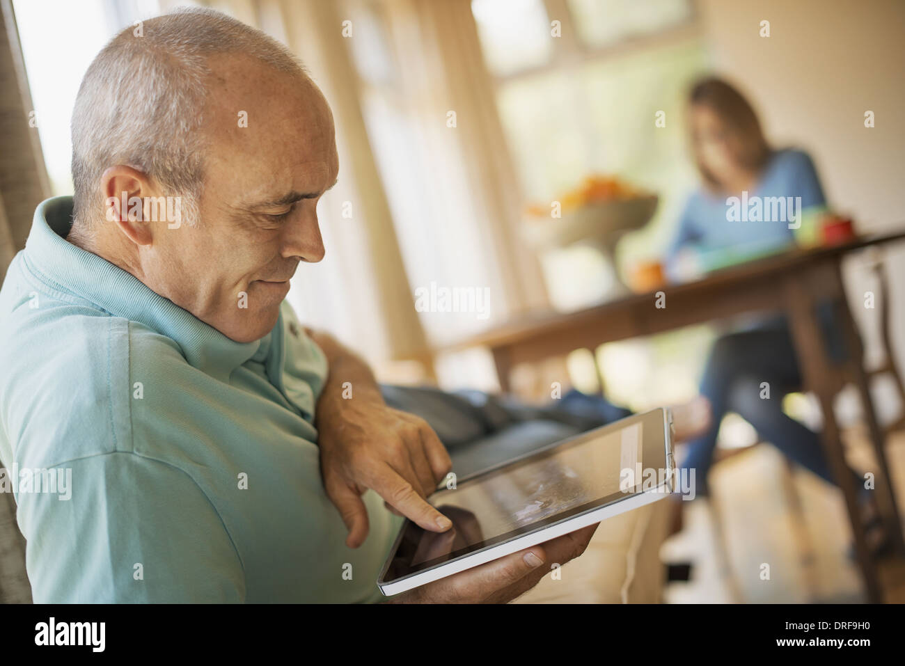 New York State USA Mann sitzt im Bauernhaus Küche digital-Tablette Stockfoto