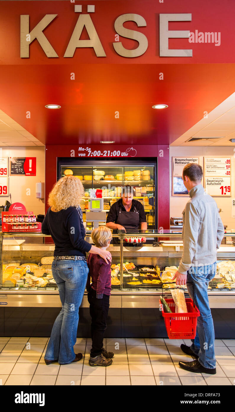 Junge Familie einkaufen im Supermarkt, Käsetheke. Stockfoto