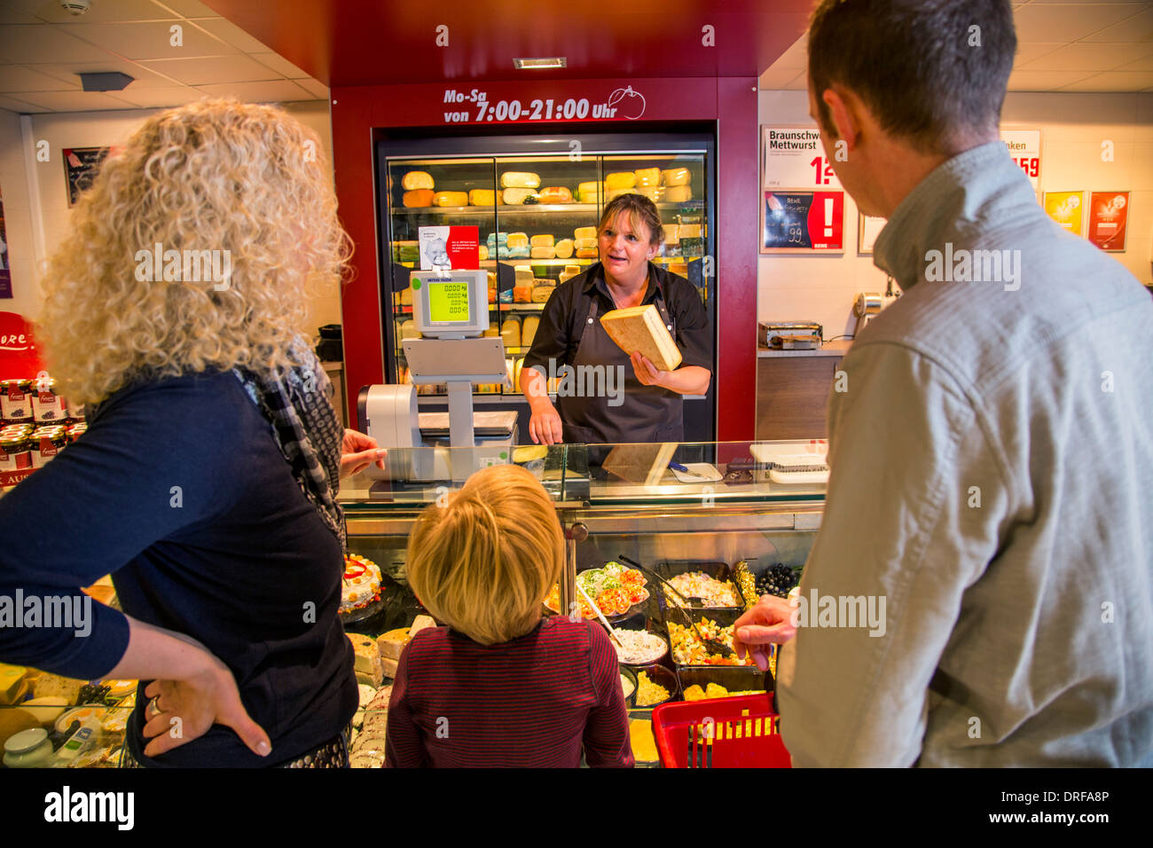 Junge Familie einkaufen im Supermarkt, Käsetheke. Stockfoto