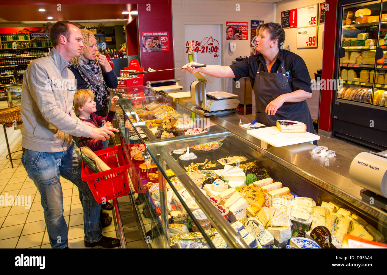 Junge Familie einkaufen im Supermarkt, Käsetheke. Stockfoto