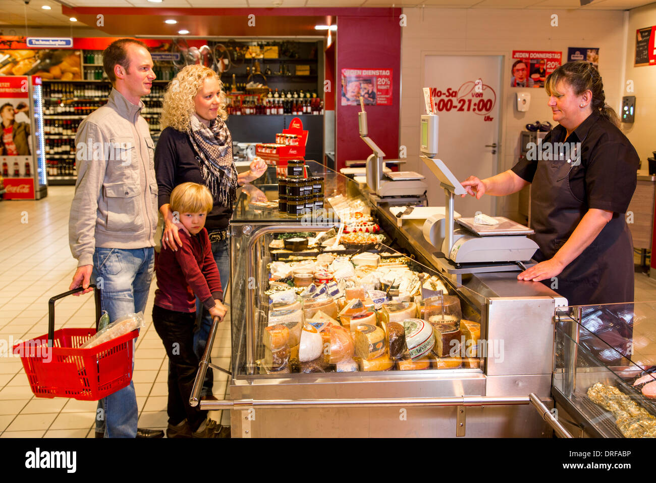 Junge Familie einkaufen im Supermarkt, Käsetheke. Stockfoto