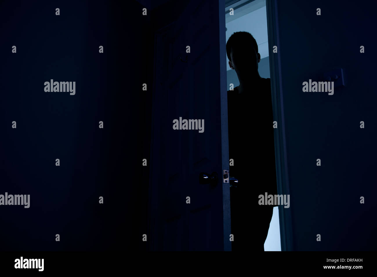 Silhouette eines Mannes in der Dunkelheit in eine offene Tür stehen. Stockfoto