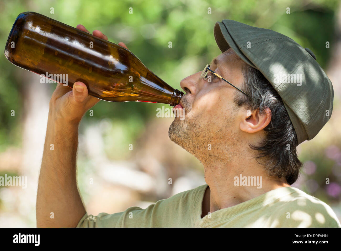 Nahaufnahme eines Mannes trinken Bier aus der Flasche im Freien. Stockfoto