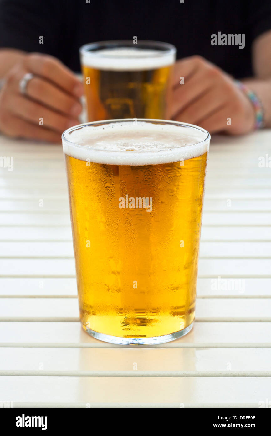 Nahaufnahme von Glas frisches Bier und die Hände auf den Tisch. Stockfoto