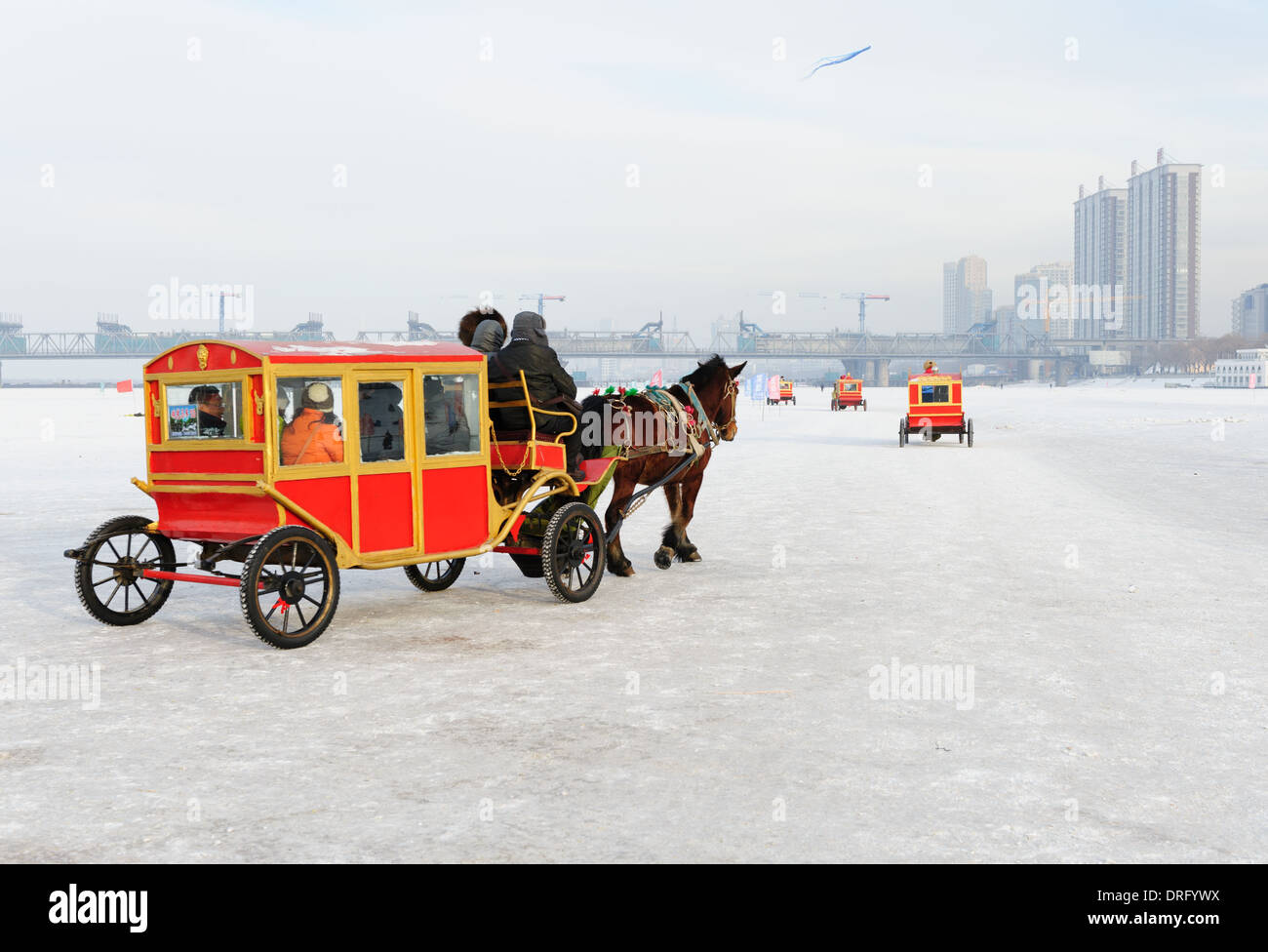 Märchenhafte Streitwagen mit Touristen machen ihre Runden auf dem gefrorenen Fluss Songhua-Fluss. 2014 internationale Eis- und Schneefestival Harbin Stockfoto